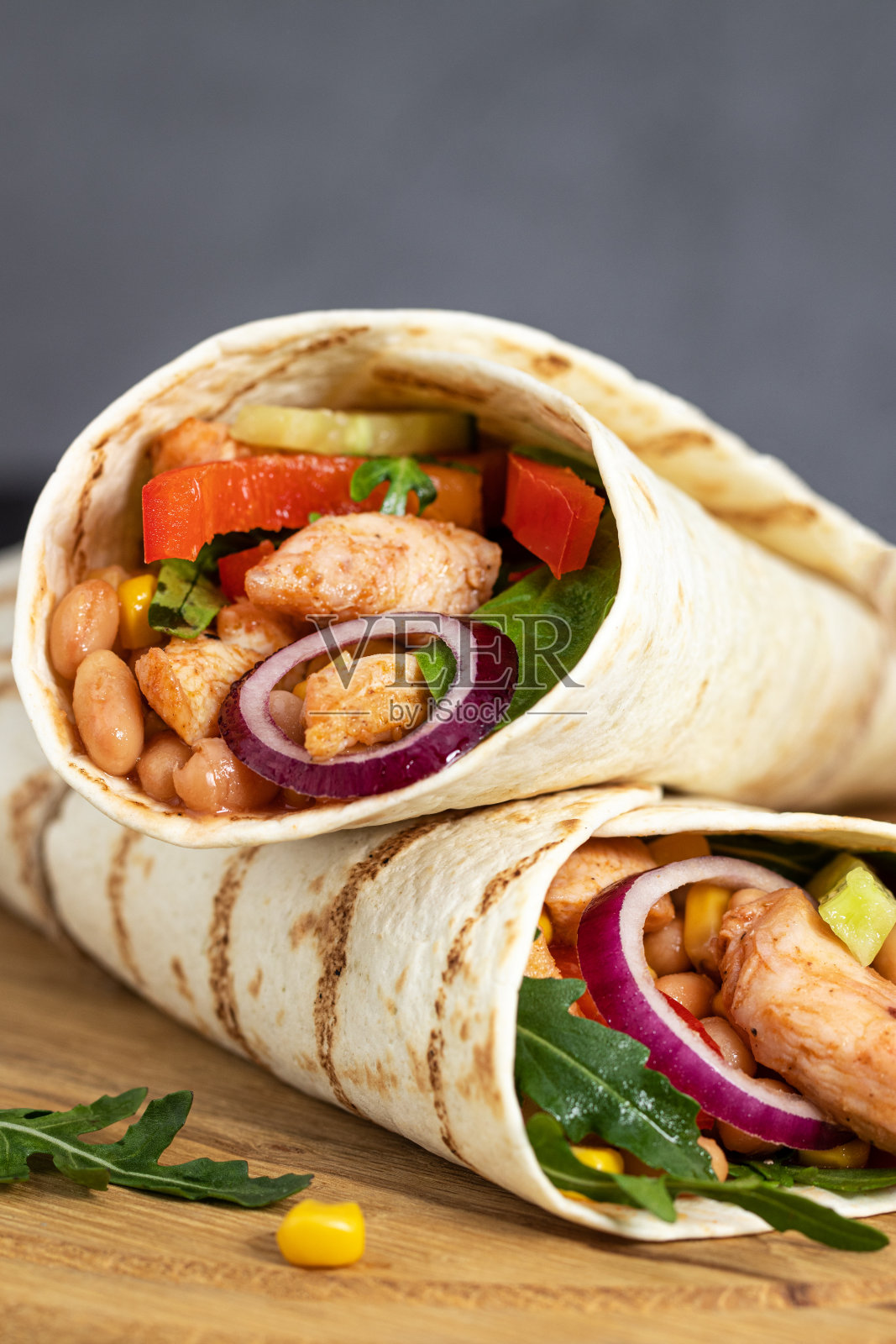 墨西哥卷饼是用鸡肉和蔬菜包裹在深色的背景上。墨西哥食物照片摄影图片