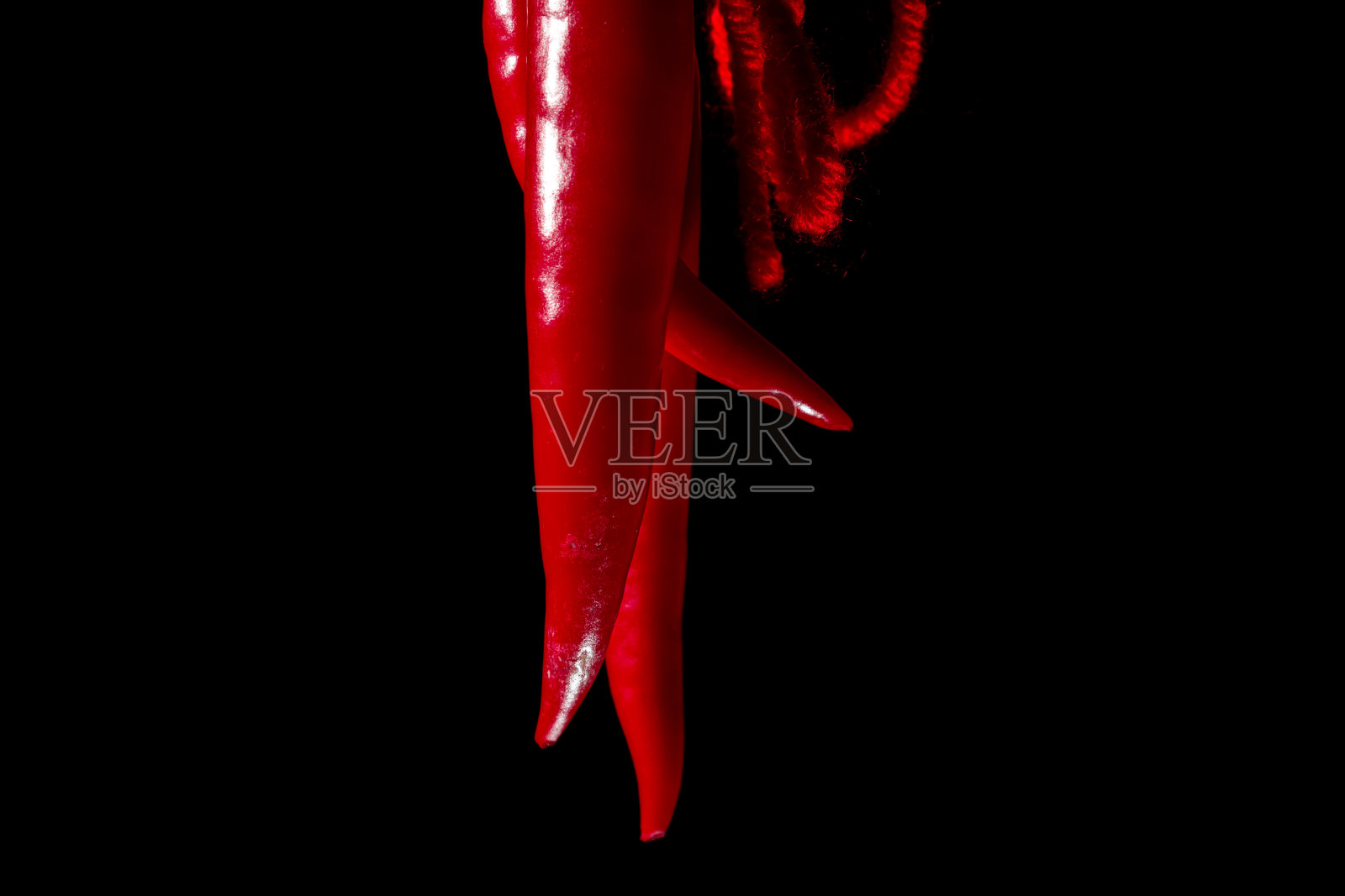 红辣椒是用红线连接起来的。性，在黑色背景下的性。复制空间关闭照片摄影图片