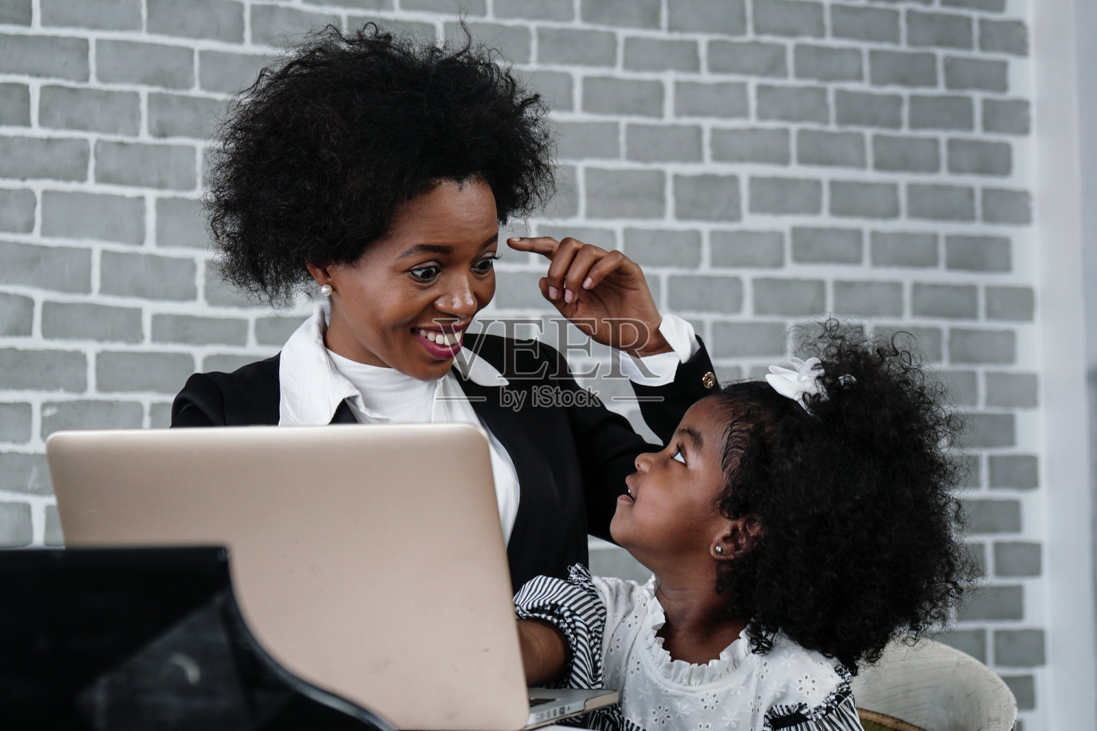 在家工作时照顾女儿的非裔美国女商人照片摄影图片