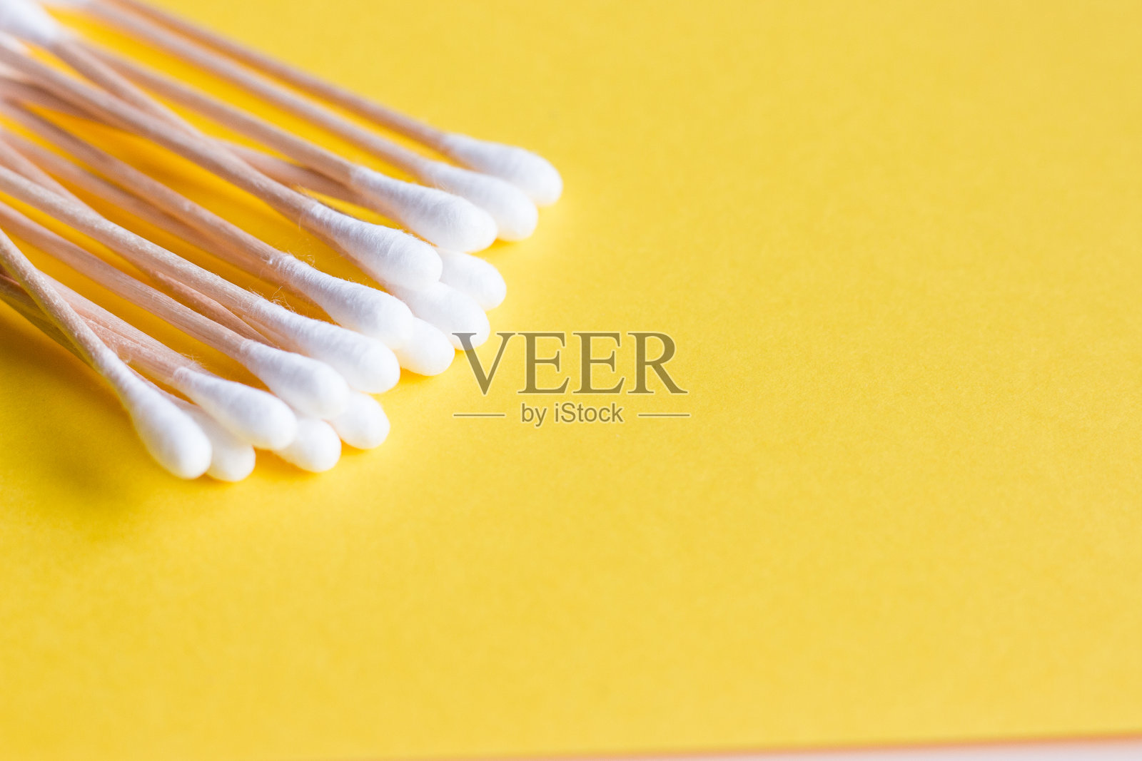 黄色背景的竹签上的医用棉签。人体卫生。环保卫生用品。照片摄影图片