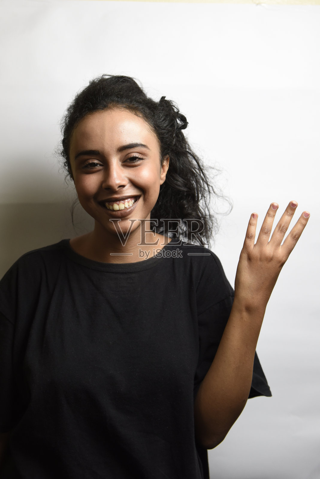 快乐的中东女孩，用手指数四照片摄影图片