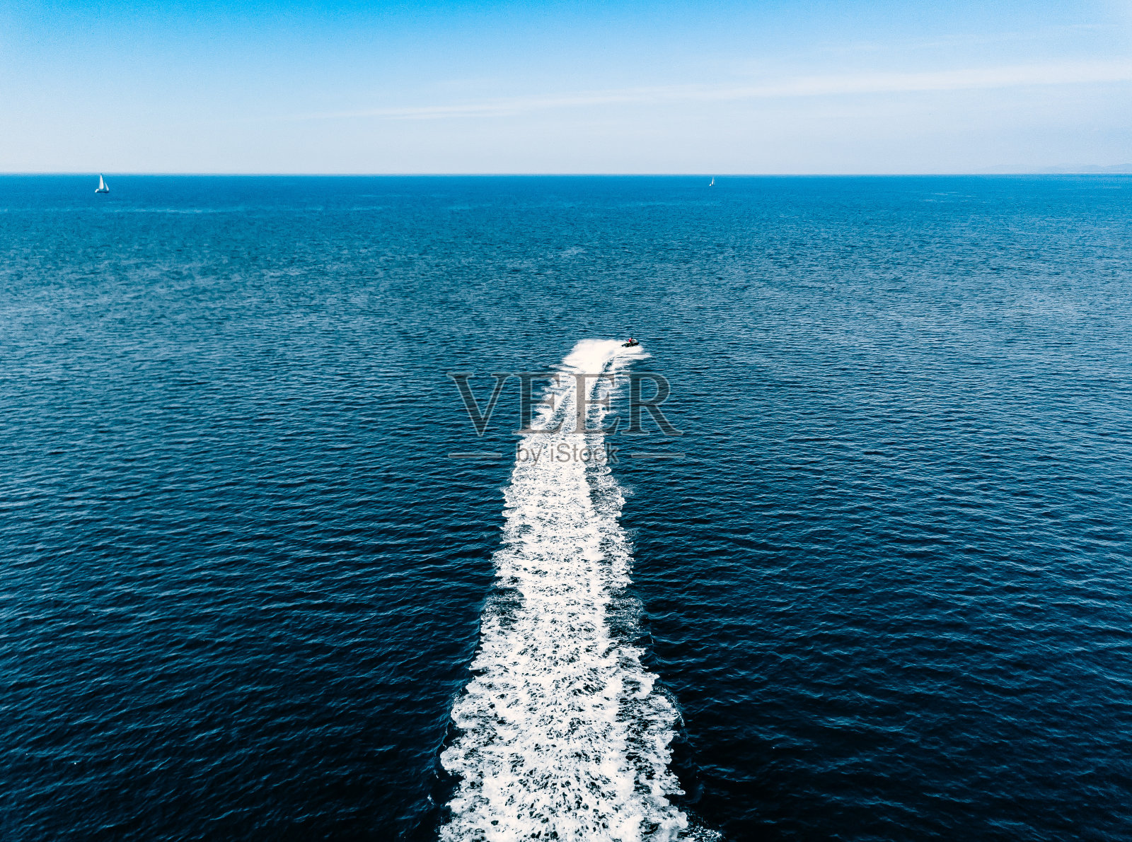 蓝色海面上喷气滑雪者的鸟瞰图。水上摩托艇在绿松石清澈的水比赛照片摄影图片