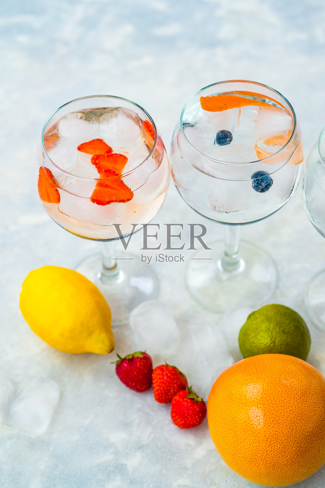 俯视图两杜松子酒鸡尾酒与草莓，酸橙和蓝莓。照片摄影图片