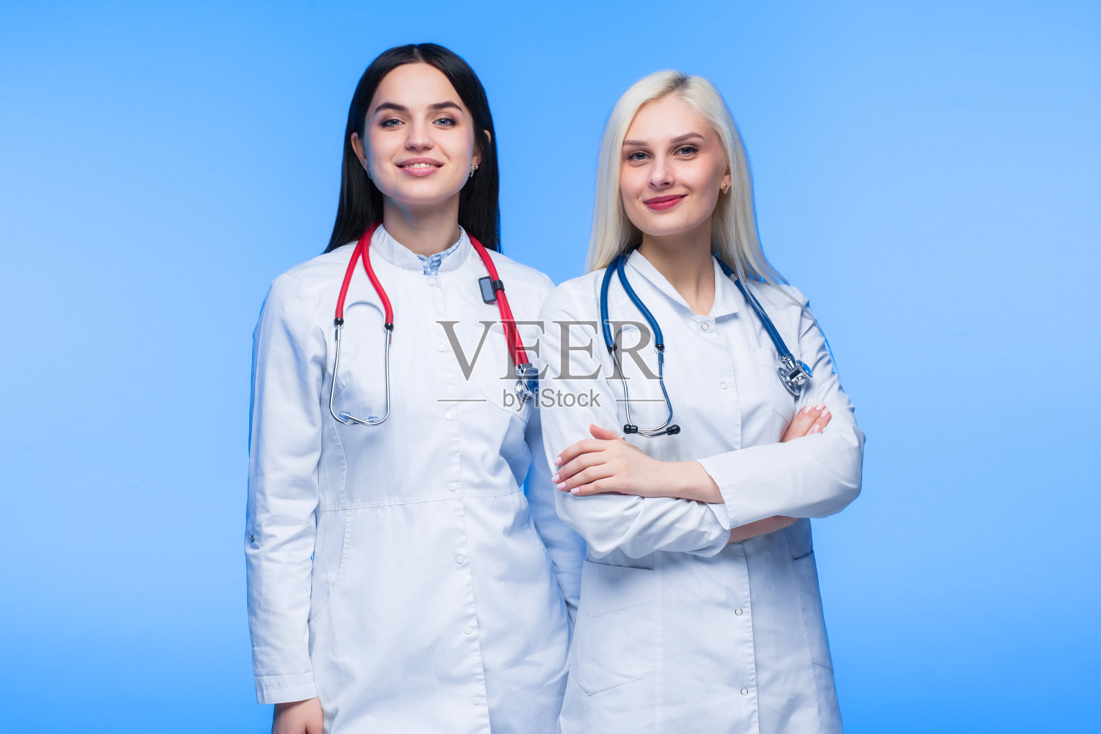 一群年轻的居民。蓝色背景是医生，护士和外科医生。一群不同国籍的医科学生正在牢房里看照片摄影图片