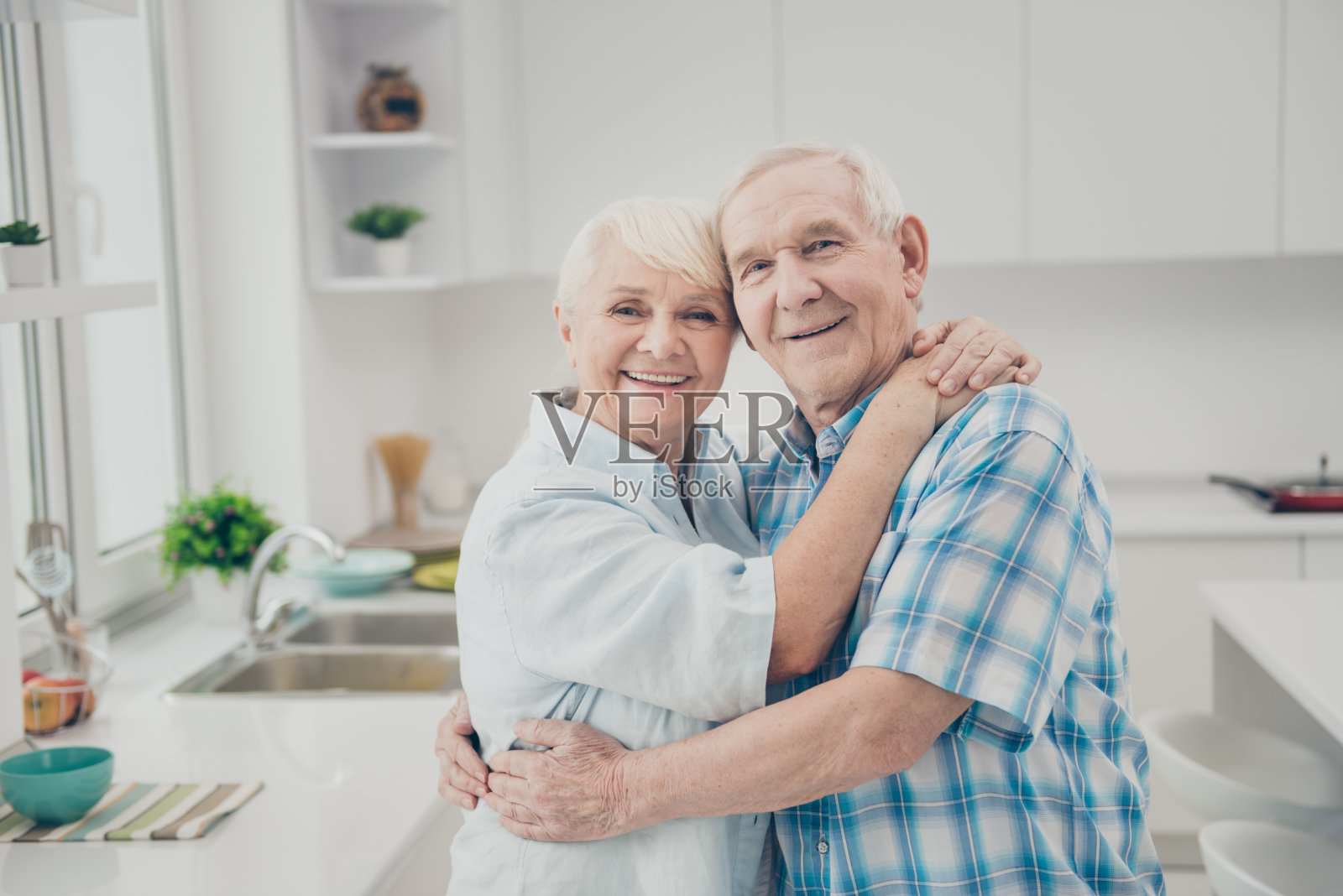 迷人的夫妇的肖像看起来感到高兴穿格子衬衫站在厨房室内照片摄影图片