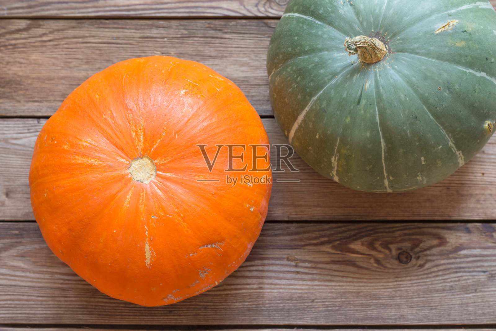橙色和绿色的南瓜特写在一个木制的背景。照片摄影图片