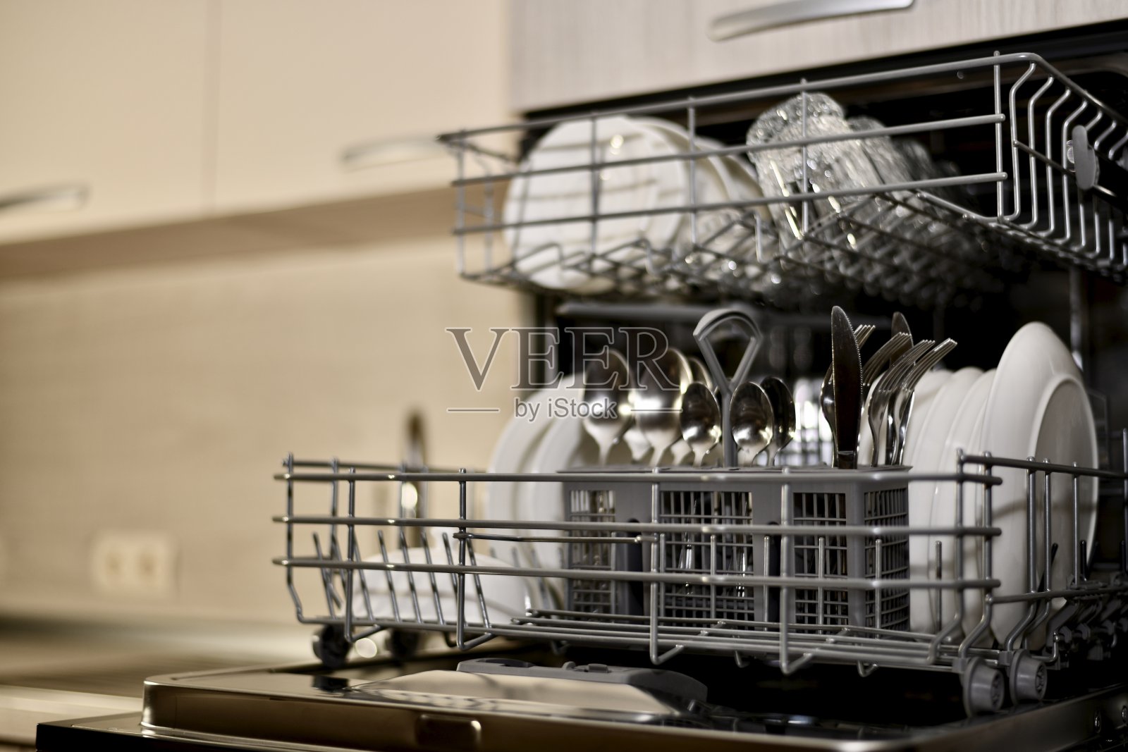 厨房橱柜里的洗碗机打开了一个视角，几乎完全模糊。照片摄影图片