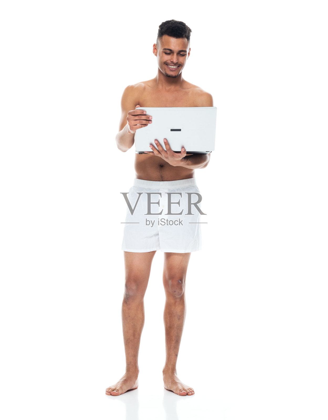 非裔美国人年轻男性穿着内衣站着用笔记本电脑照片摄影图片