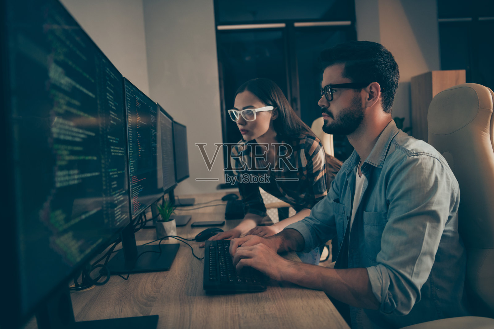 it专家的资料照片两个商务人士晚上共同工作的人一起纠正错误错误写界面代码女士看检查html java脚本办公室室内照片摄影图片