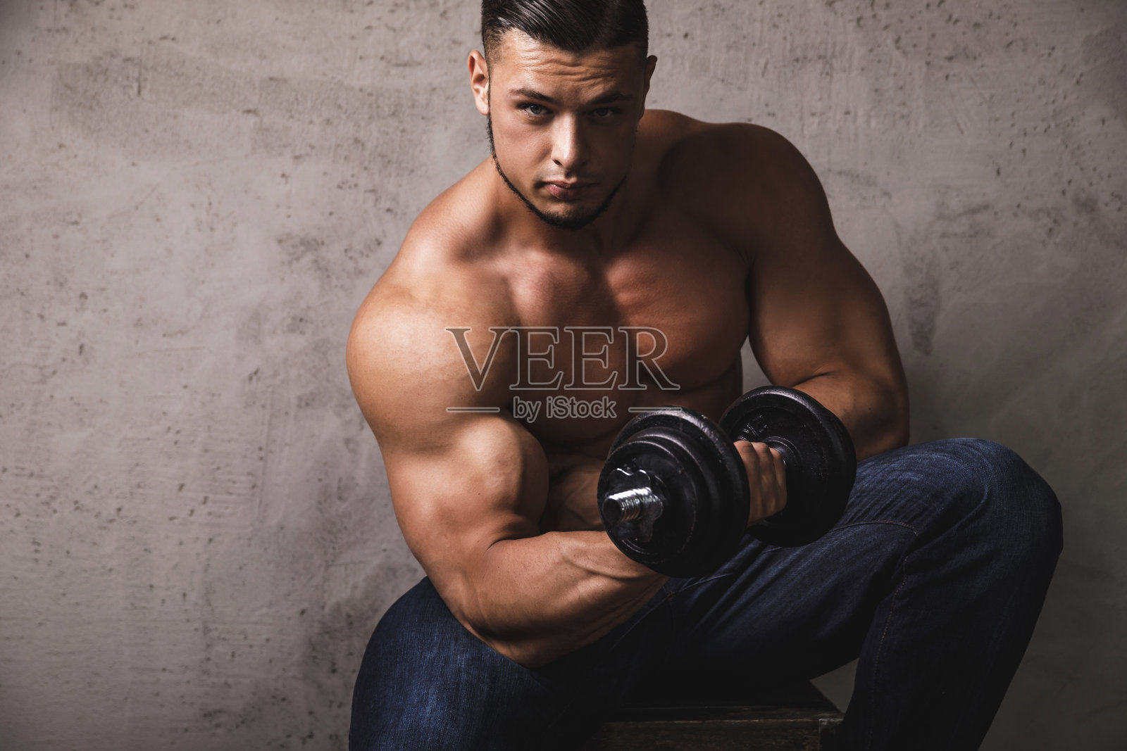 正在用哑铃做肱二头肌弯举的健壮男人照片摄影图片