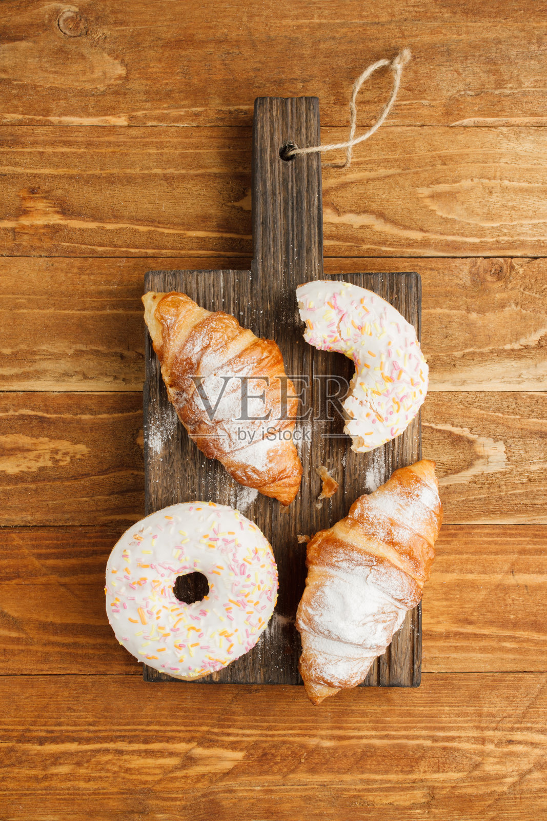 羊角面包和甜甜圈的木制背景照片摄影图片