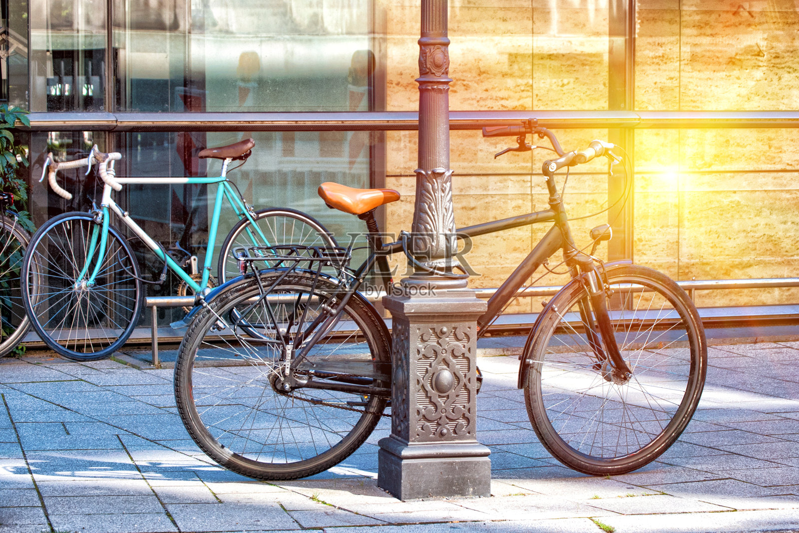 日落时分，路灯站的自行车。照片摄影图片