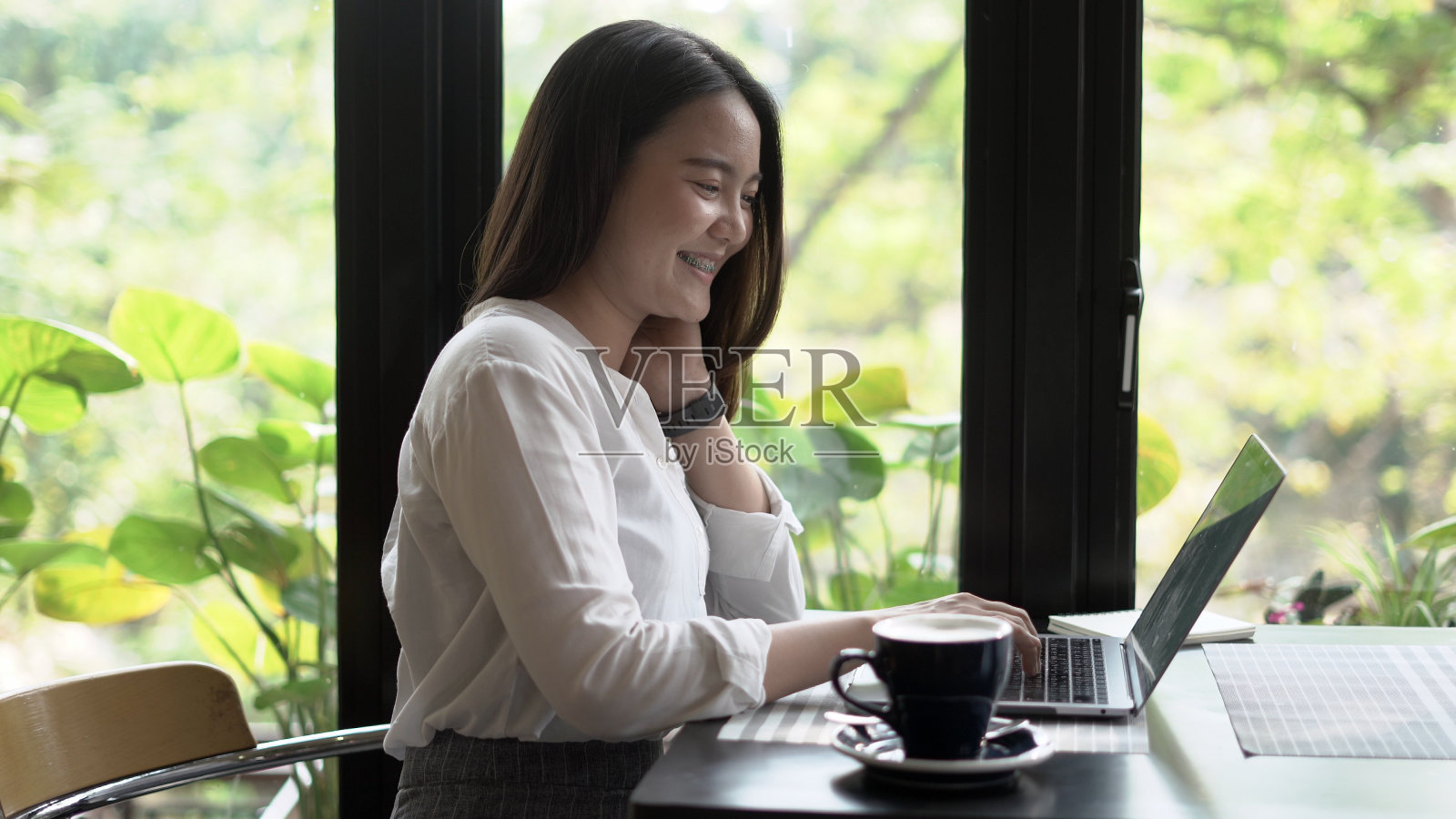 美丽的女人在咖啡馆里用笔记本电脑工作照片摄影图片