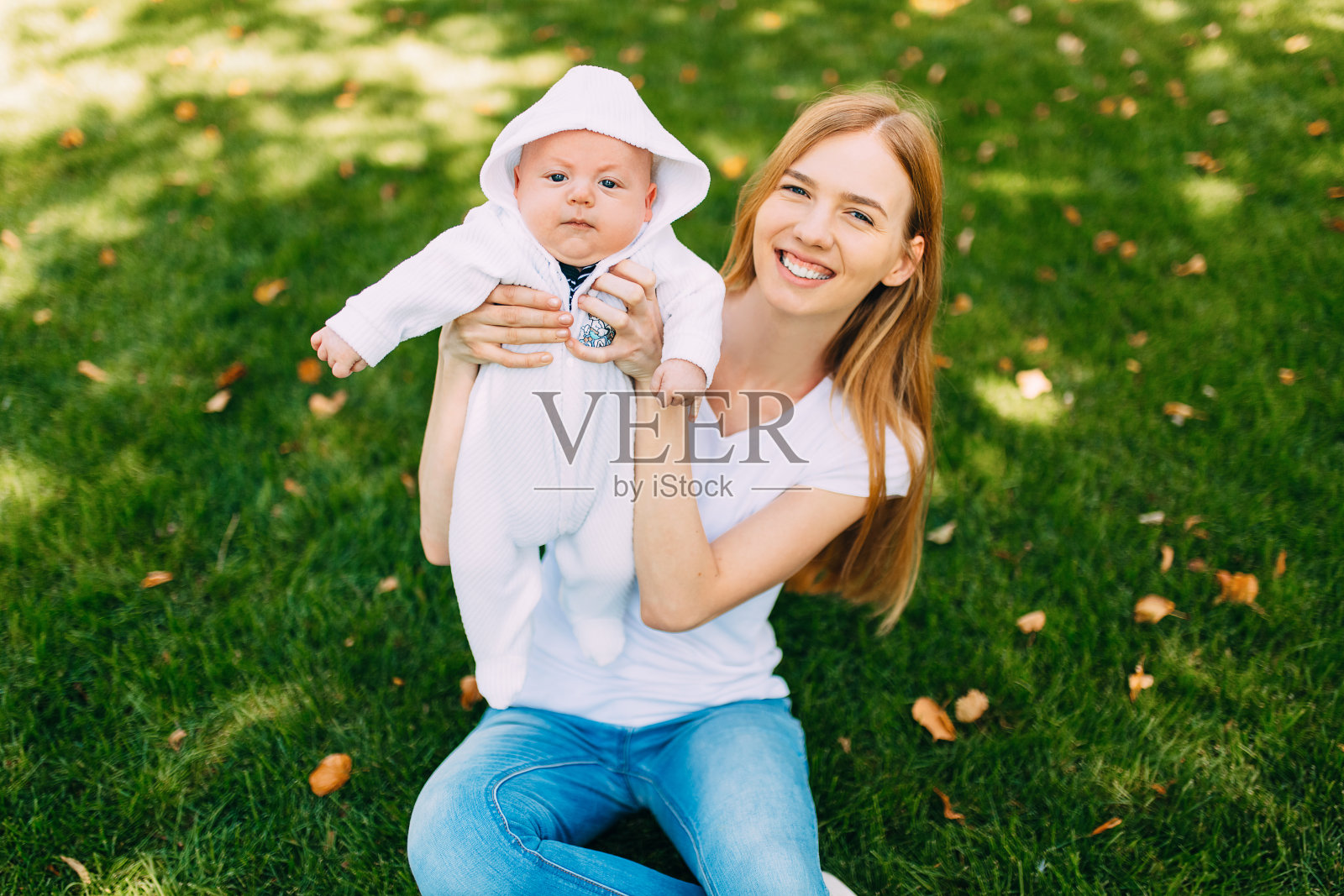 新鲜空气中幸福的家庭，母亲抱着婴儿照片摄影图片