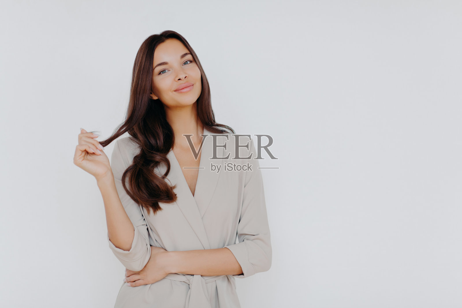 黑发女律师的孤立镜头，职业主顾穿着正式服装，等待客户，站在白色背景下，复制空间。成功的银行家有自信的面部表情照片摄影图片