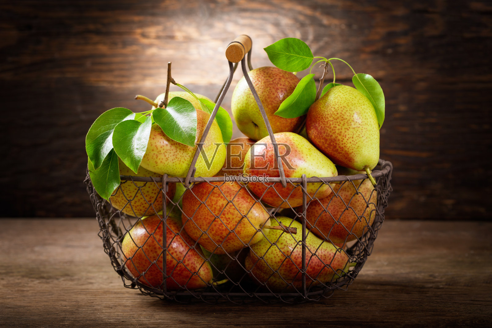 木桌上的篮子里装着新鲜的梨照片摄影图片