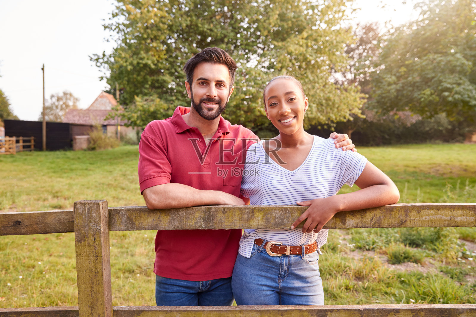 浪漫情侣在乡村散步时在栅栏上休息写真照片摄影图片
