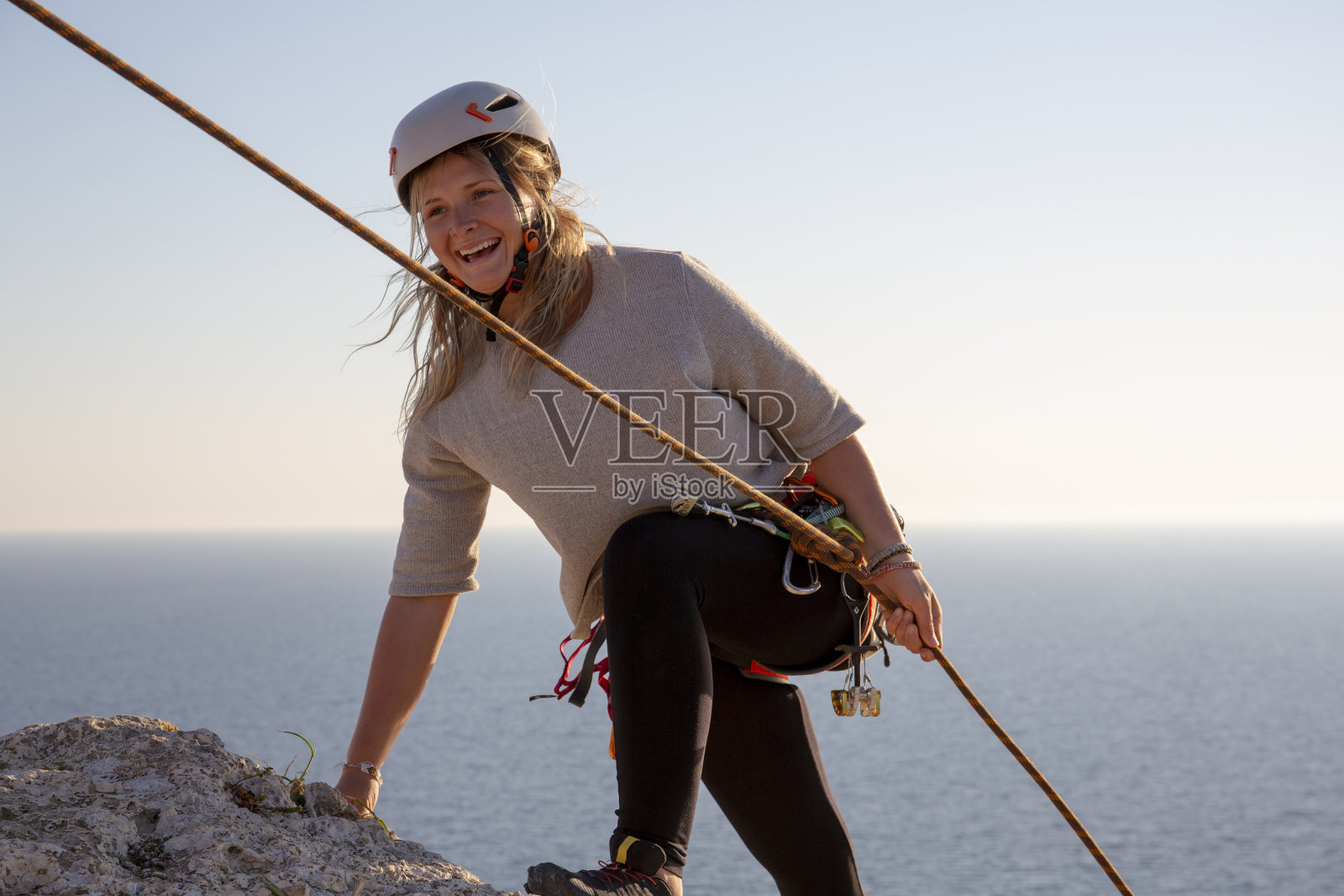 年轻女子到达攀岩顶峰照片摄影图片