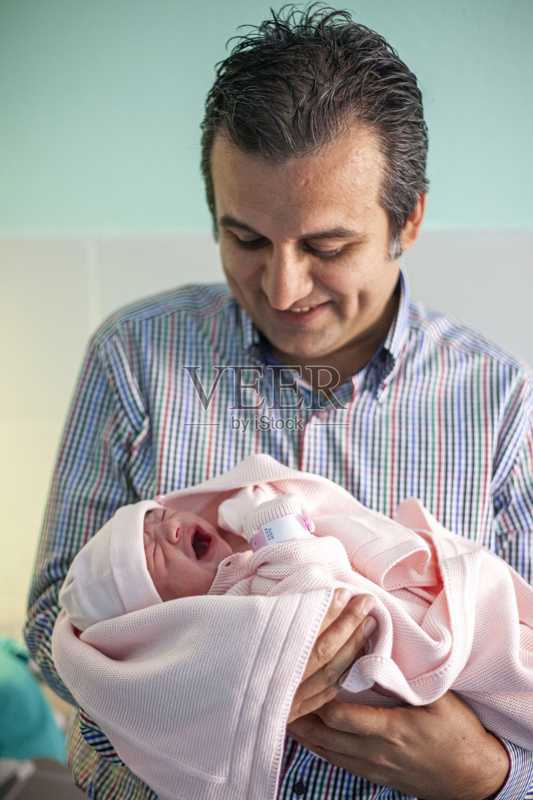 年轻的父亲抱着他刚出生的女儿照片摄影图片