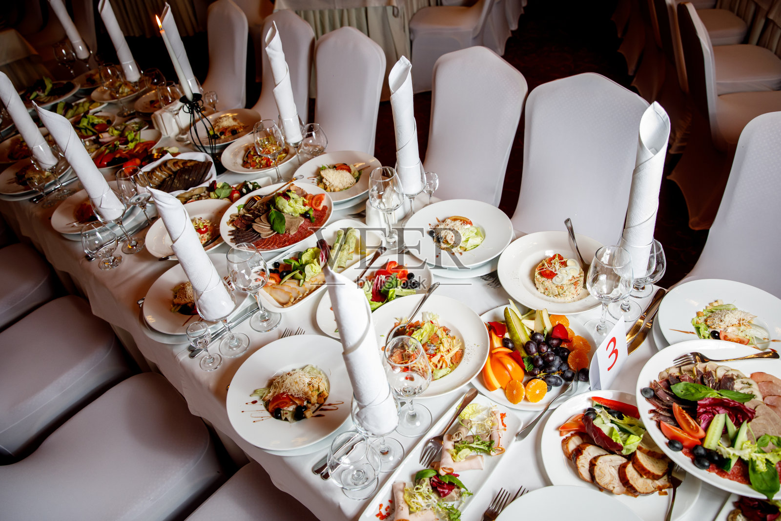 宴会前摆着食物的桌子。准备好宾客大厅。照片摄影图片