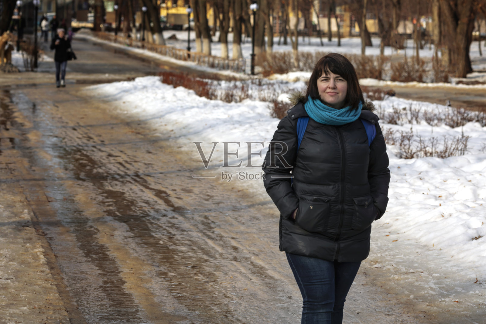 一个年轻女孩在公园的小路上行走照片摄影图片