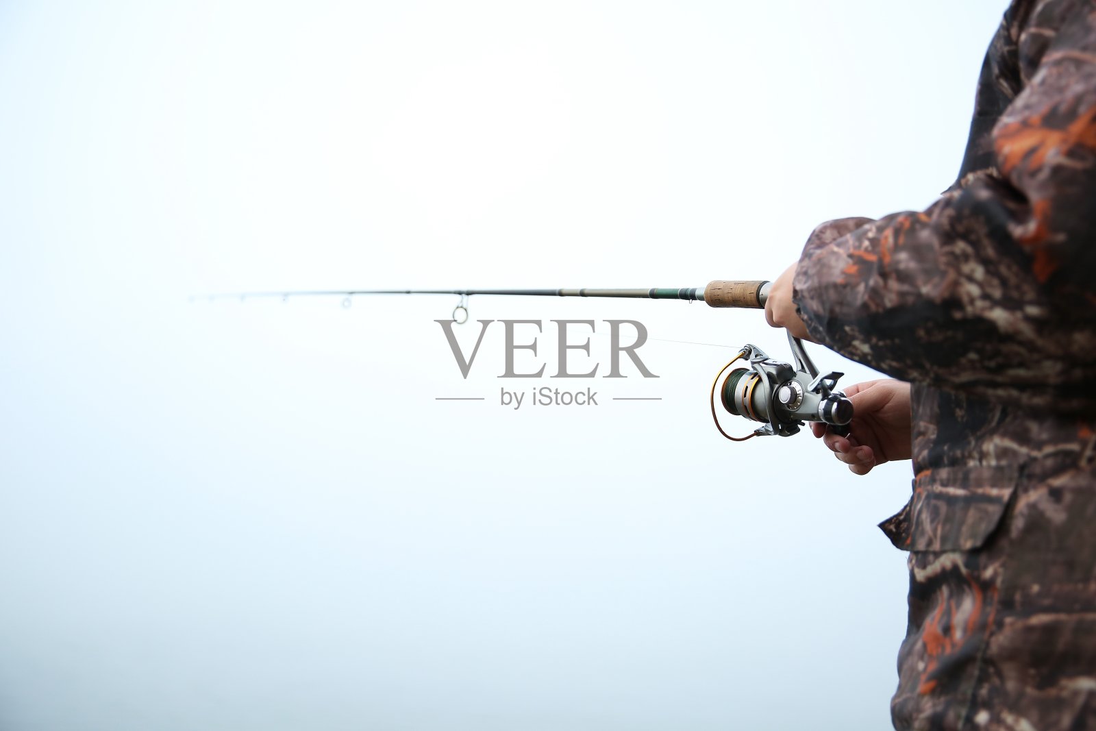 渔夫在河边拿着钓鱼竿照片摄影图片