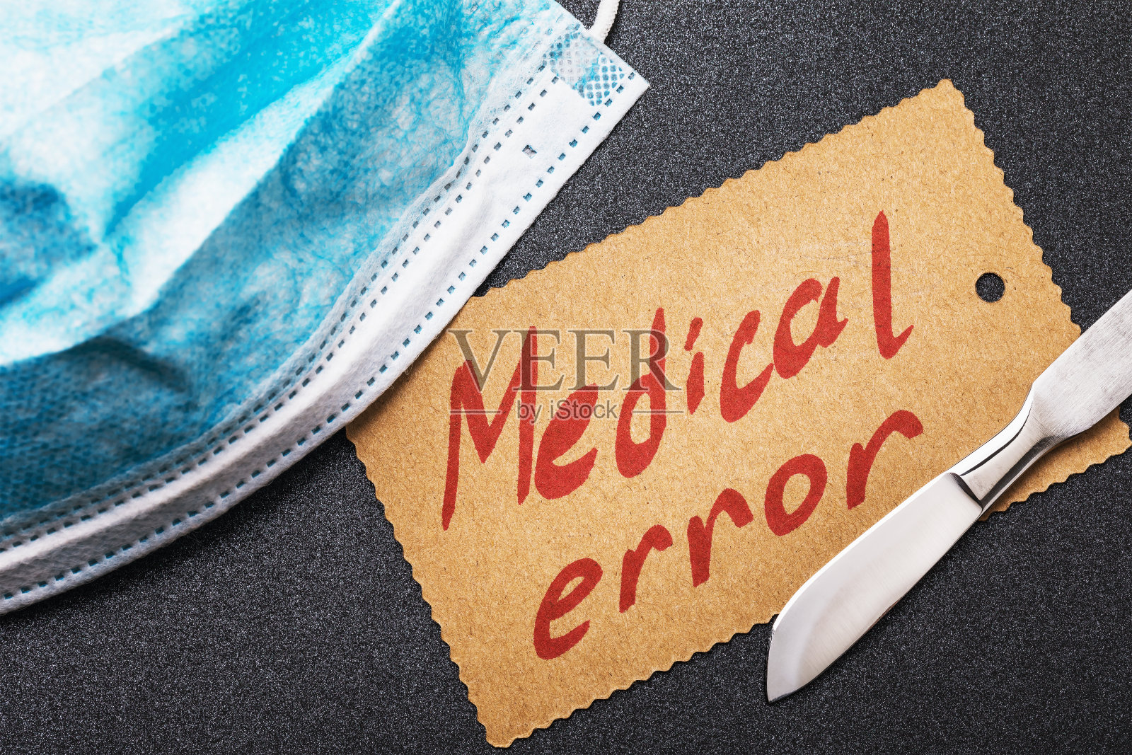 面罩、手术刀和带有文字的纸张。医疗事故概念照片摄影图片