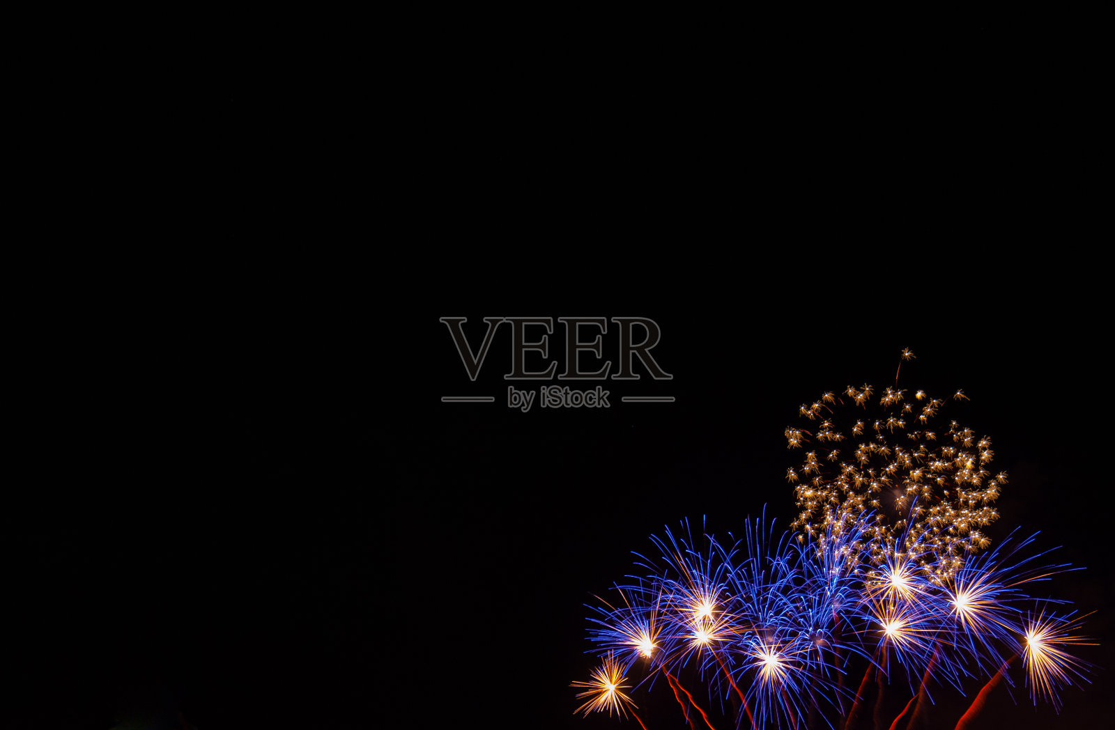 白色中心的蓝色星爆烟花和黑色背景的小金色烟花照片摄影图片