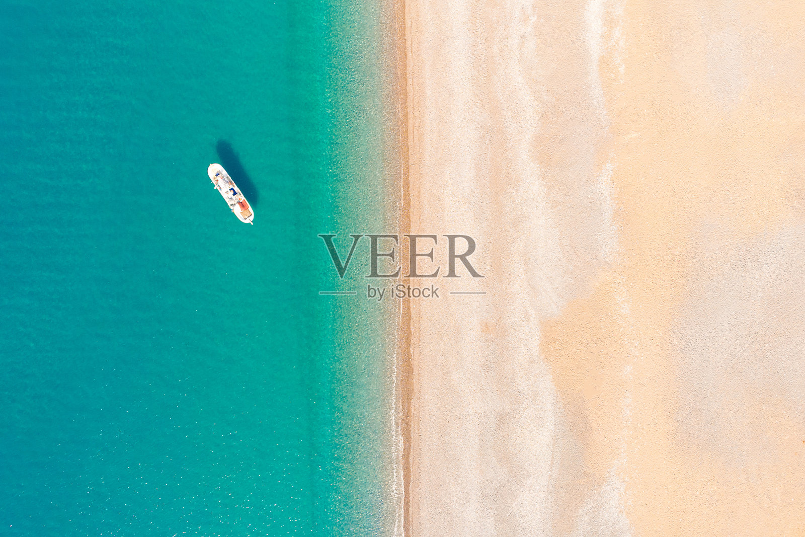 那艘白色游艇在离海岸不远的锚地上。四轴飞行器的俯视图。照片摄影图片