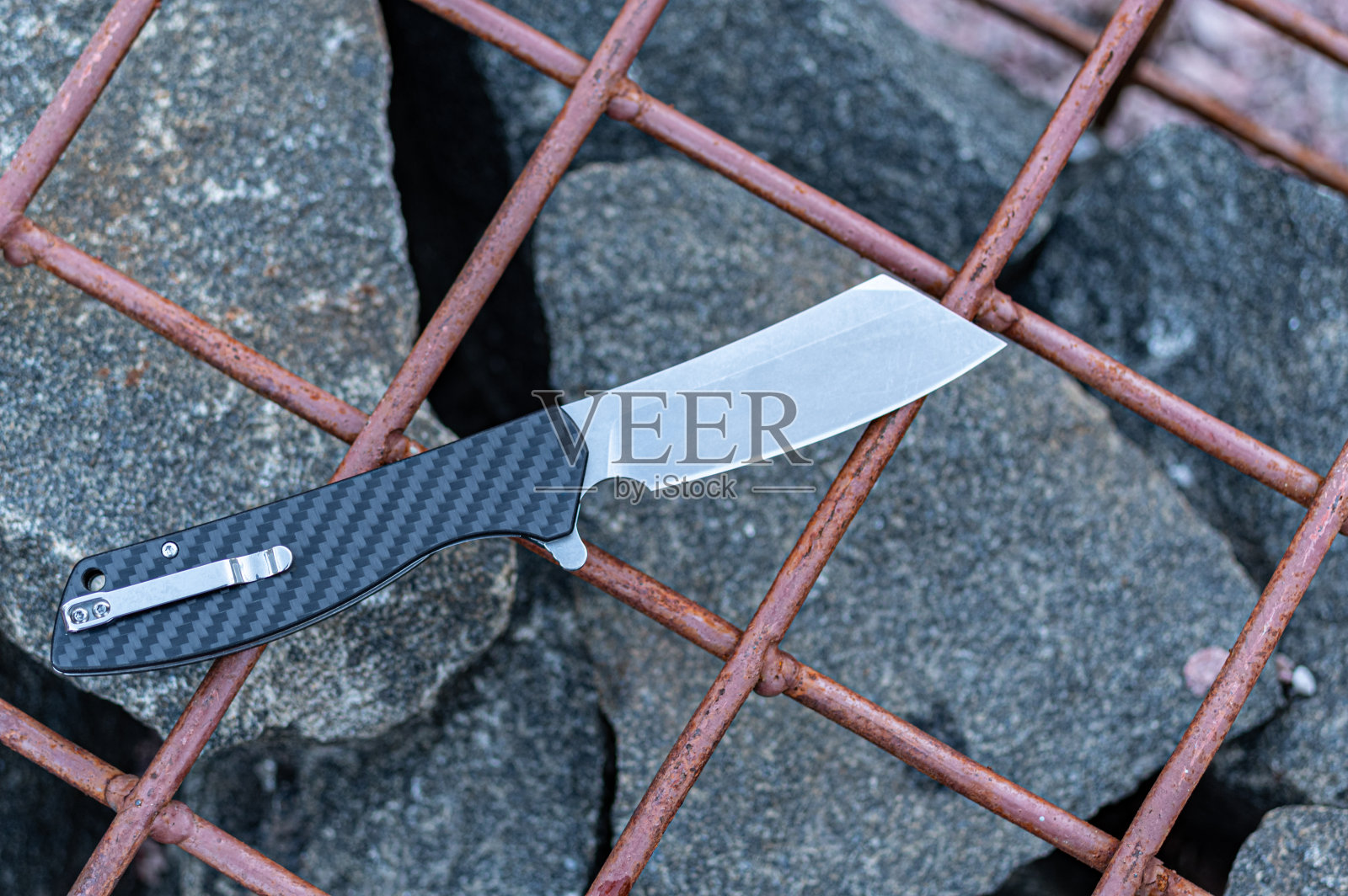 碳柄夹刀。那把刀放在铁栅栏上。照片摄影图片