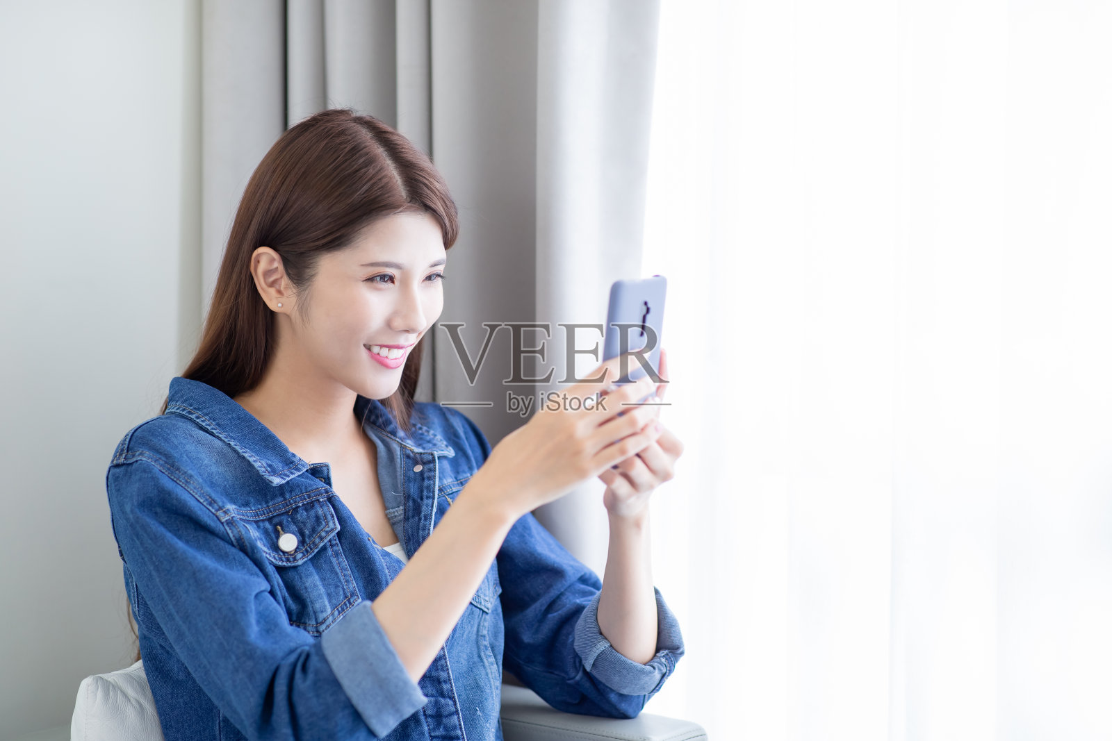 亚洲美容用智能手机照片摄影图片