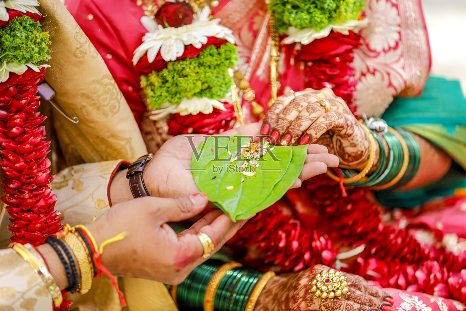 印度新郎和新娘手持挽歌或绿叶金项链照片摄影图片