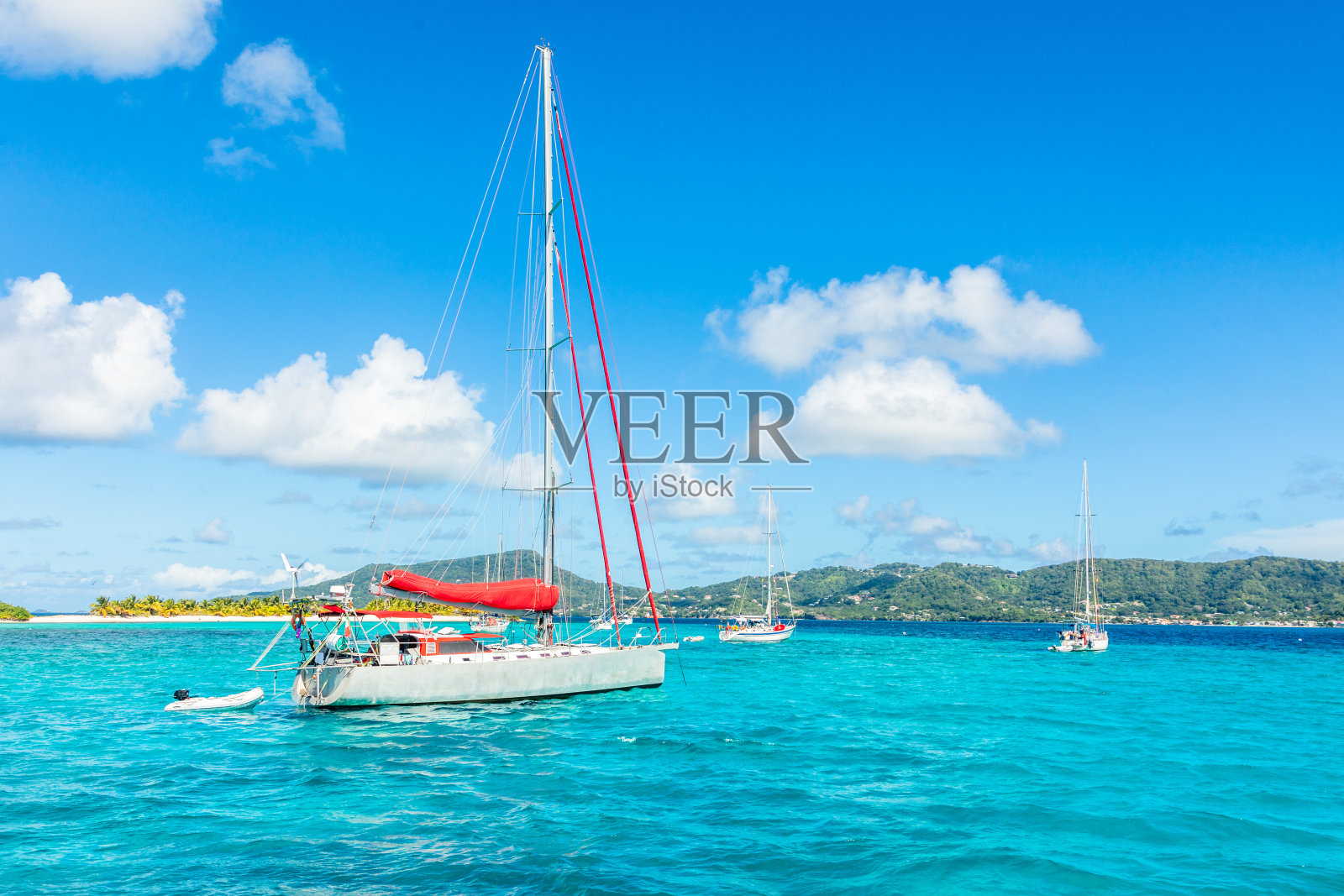 加勒比海格林纳达卡里亚库岛附近的绿松石色大海和抛锚的游艇照片摄影图片