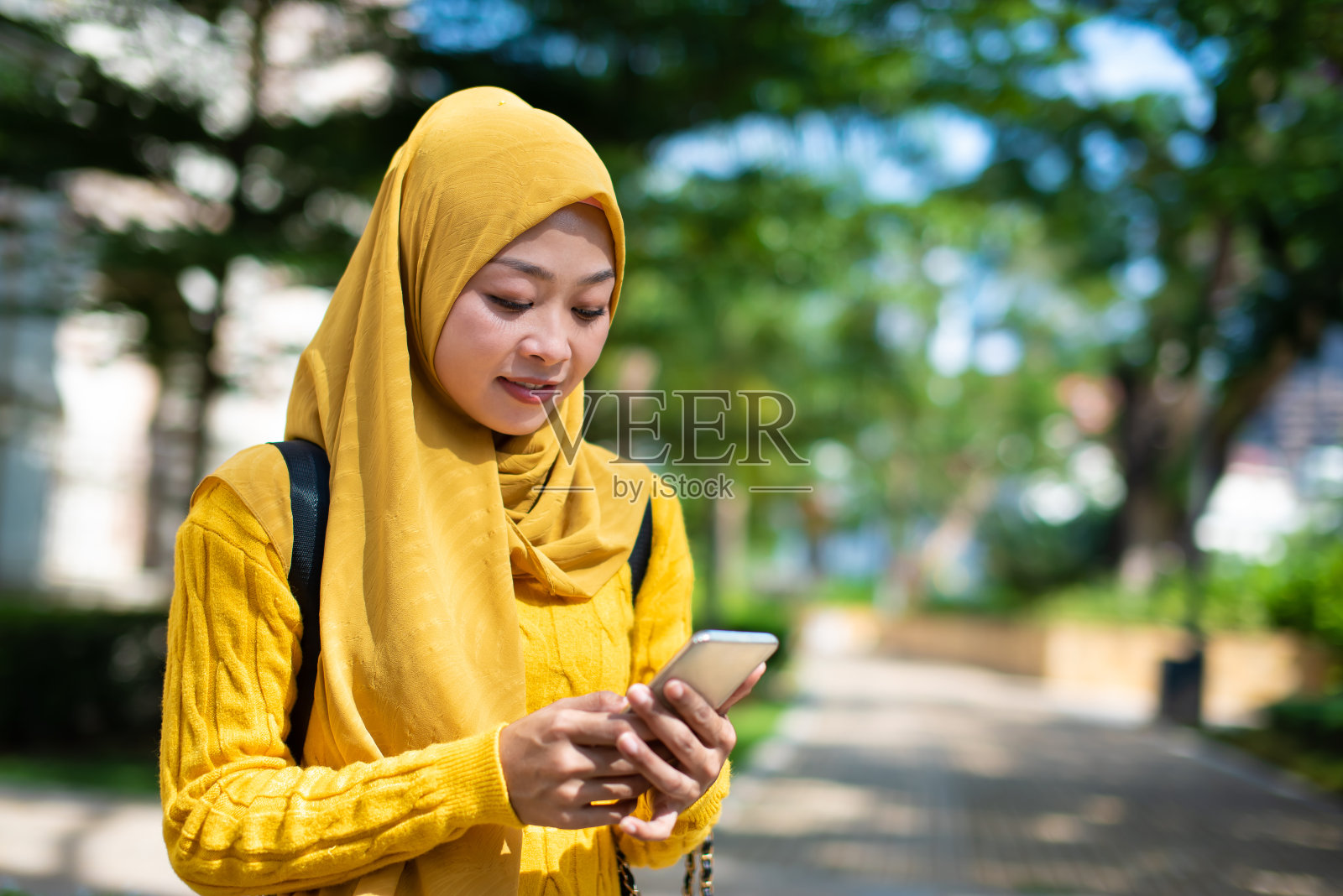 年轻的穆斯林妇女使用智能手机照片摄影图片