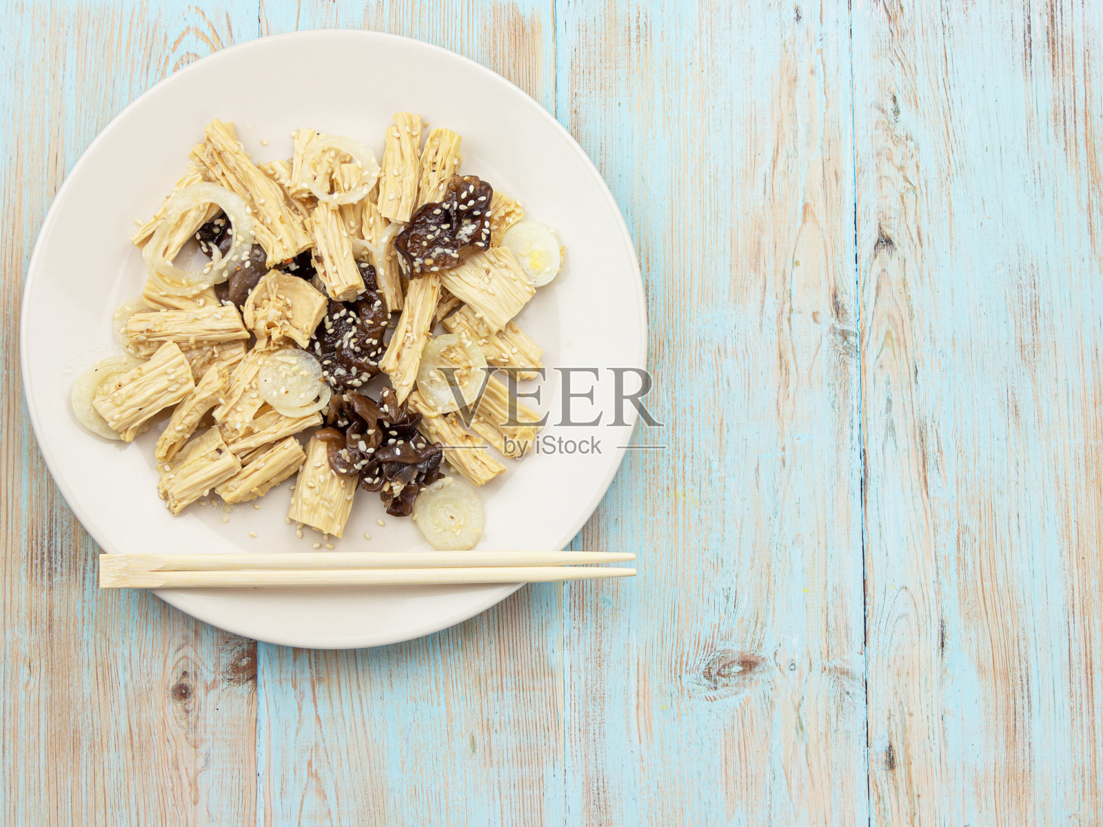 木制背景上放着辛辣的中国或韩国羽巴豆腐、竹子和平菇。照片摄影图片