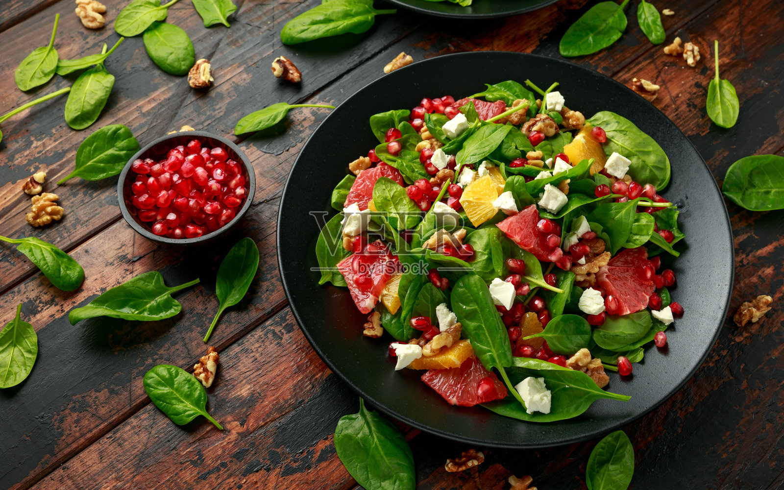 橙子柚子沙拉配菠菜，核桃，石榴籽和羊乳酪。健康的食物照片摄影图片