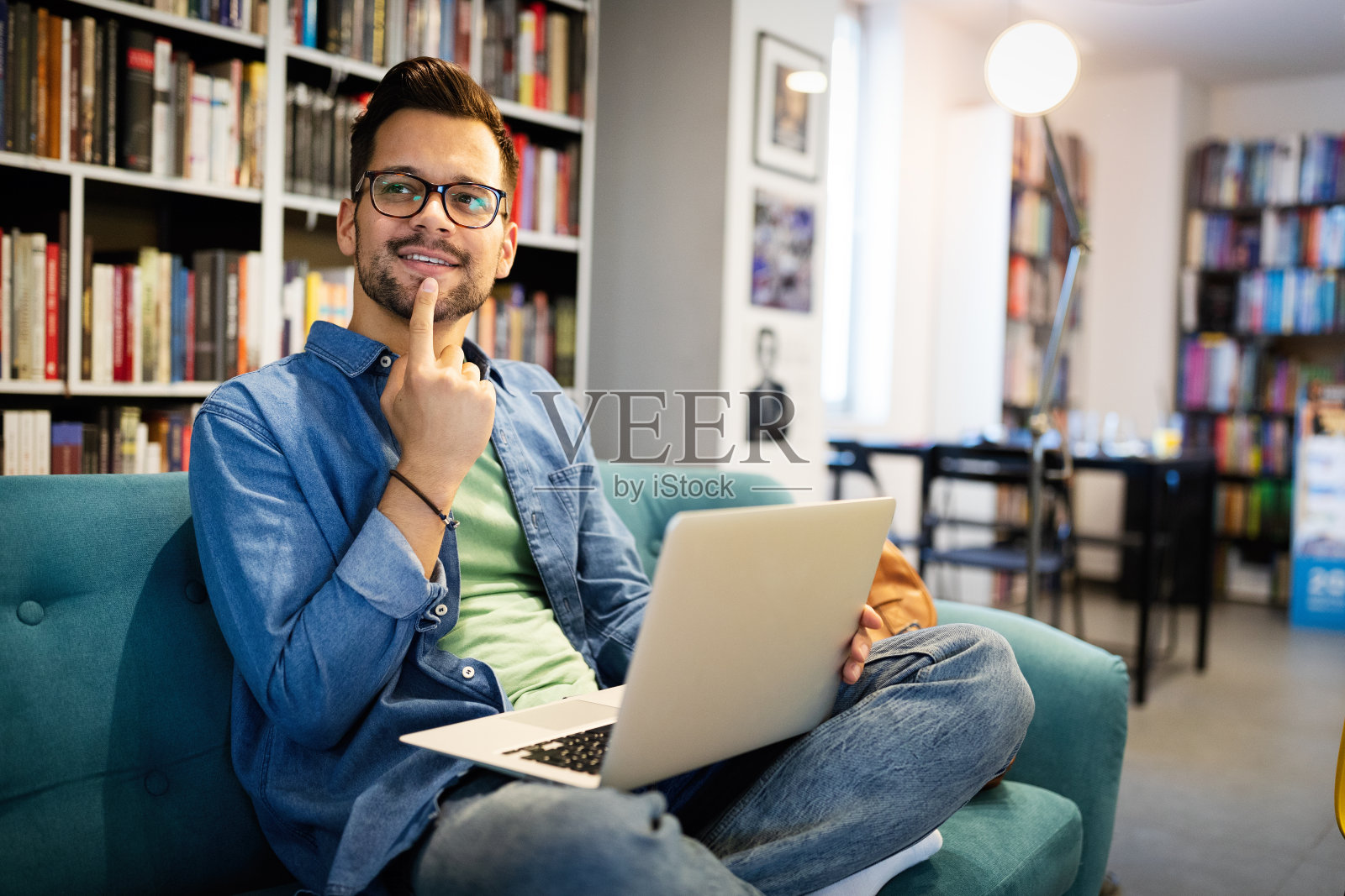 微笑的男学生在图书馆工作和学习照片摄影图片