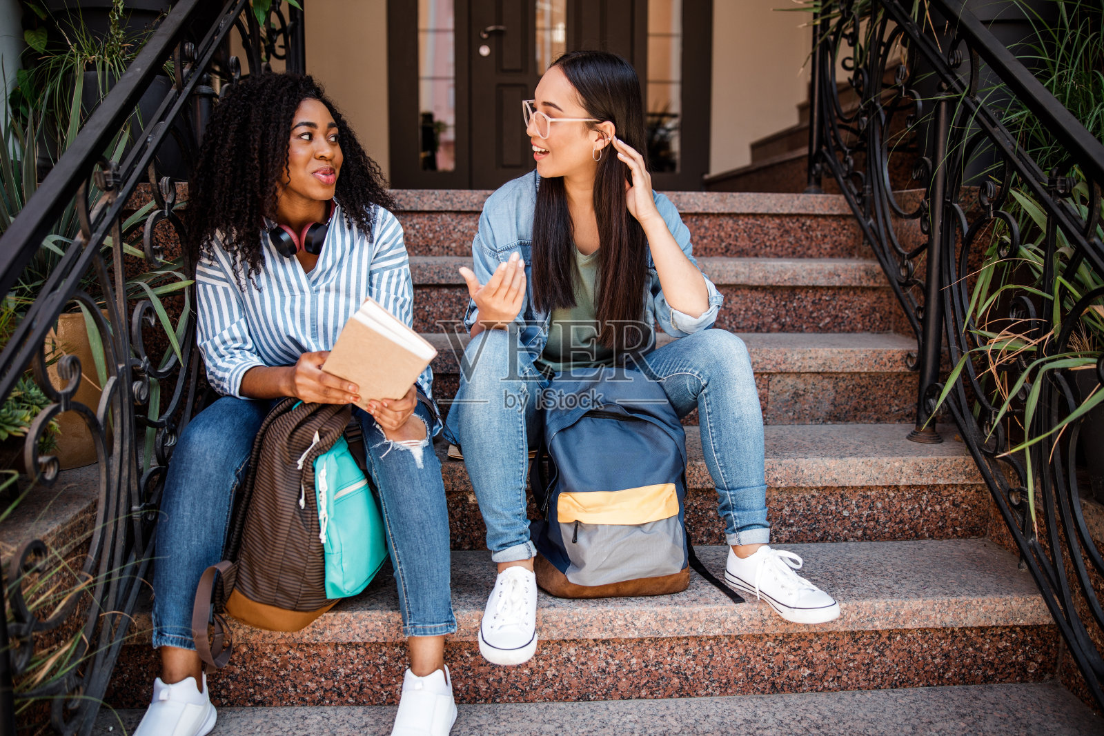 穿着牛仔服坐在楼梯上的漂亮女人照片摄影图片
