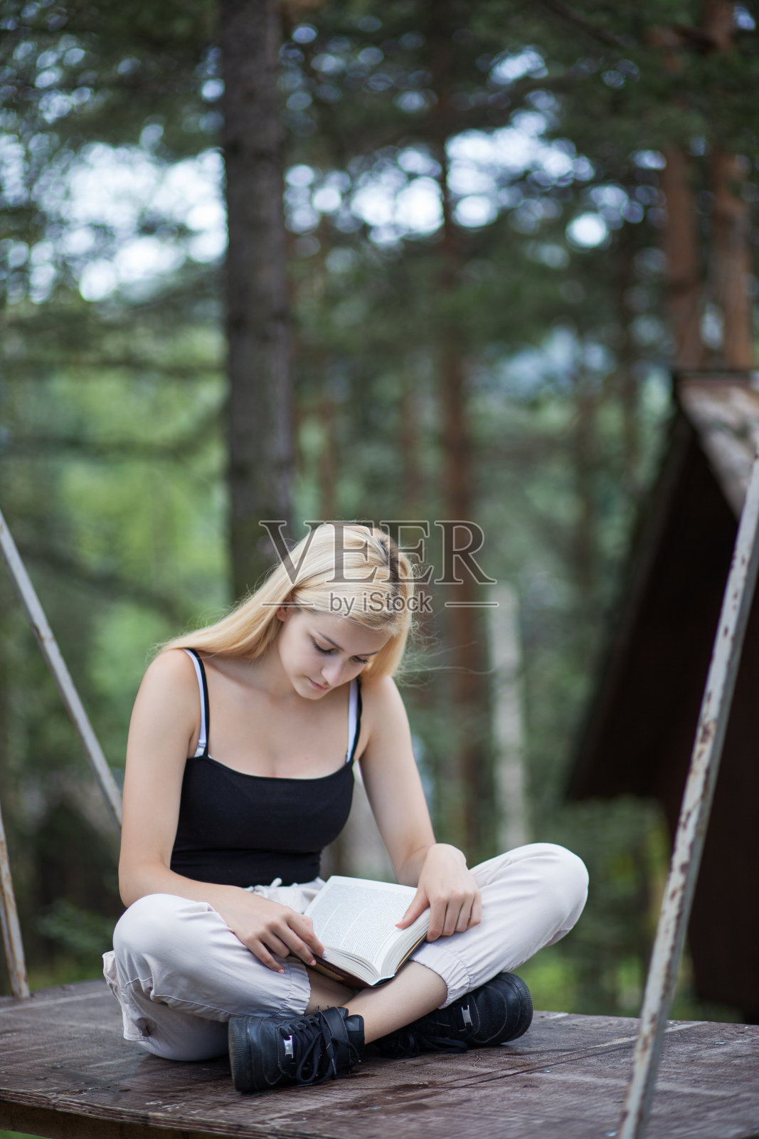年轻女人在自然环境中看书放松照片摄影图片