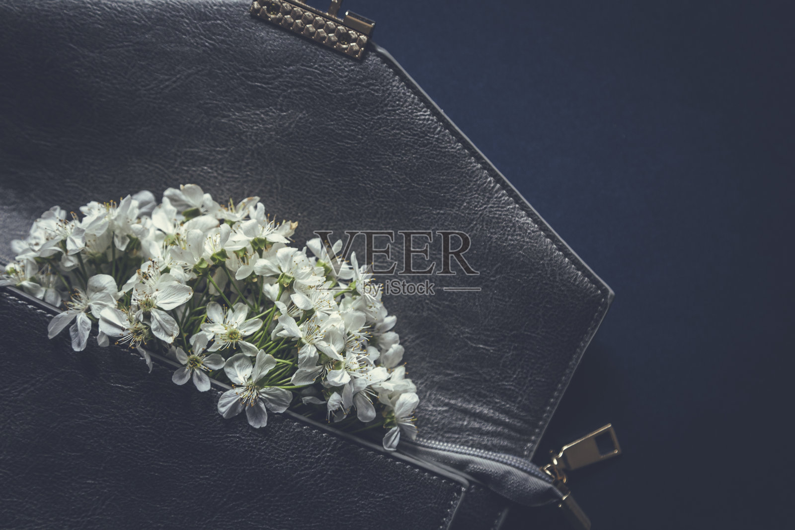 黑色手包里的花朵盛开照片摄影图片