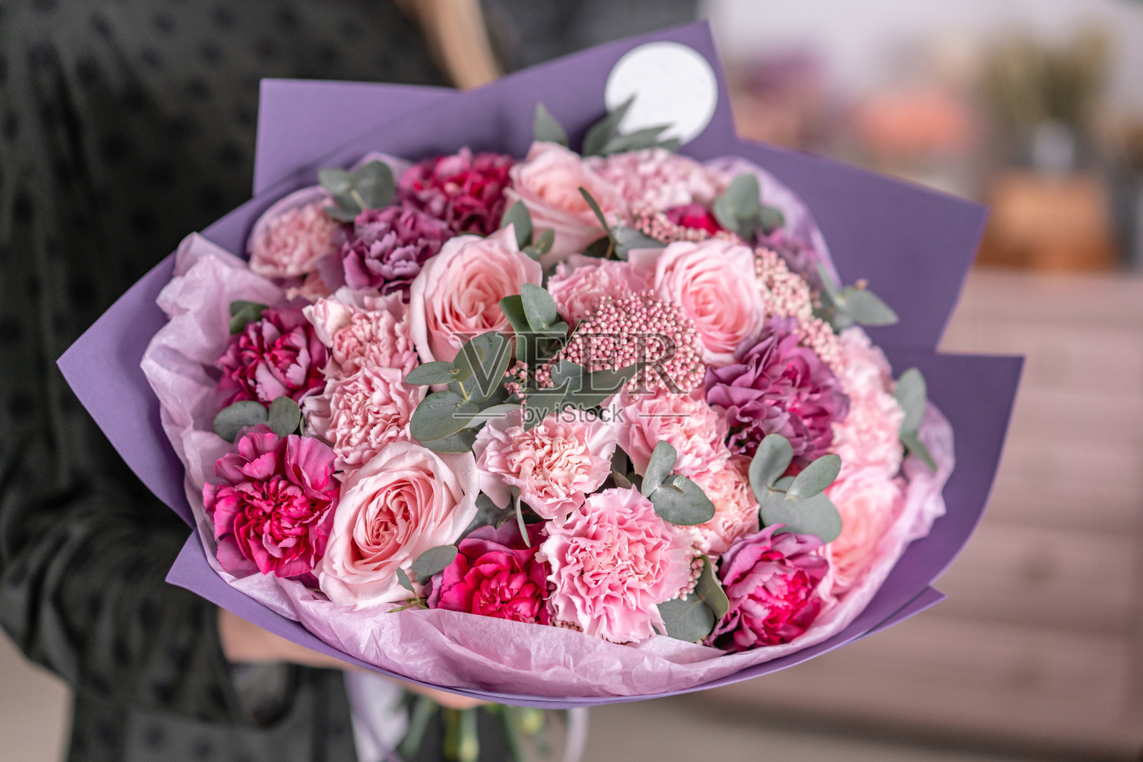 花店里，花艺师手中的混合花束照片摄影图片