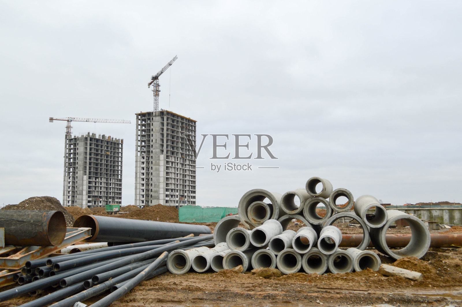 建筑工地用于建造水管或下水道的大型黑色塑料和混凝土石材水泥下水道管道照片摄影图片