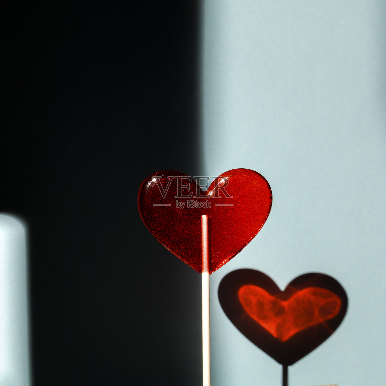 蓝色背景上的棒棒糖红心情人节简约背景照片摄影图片