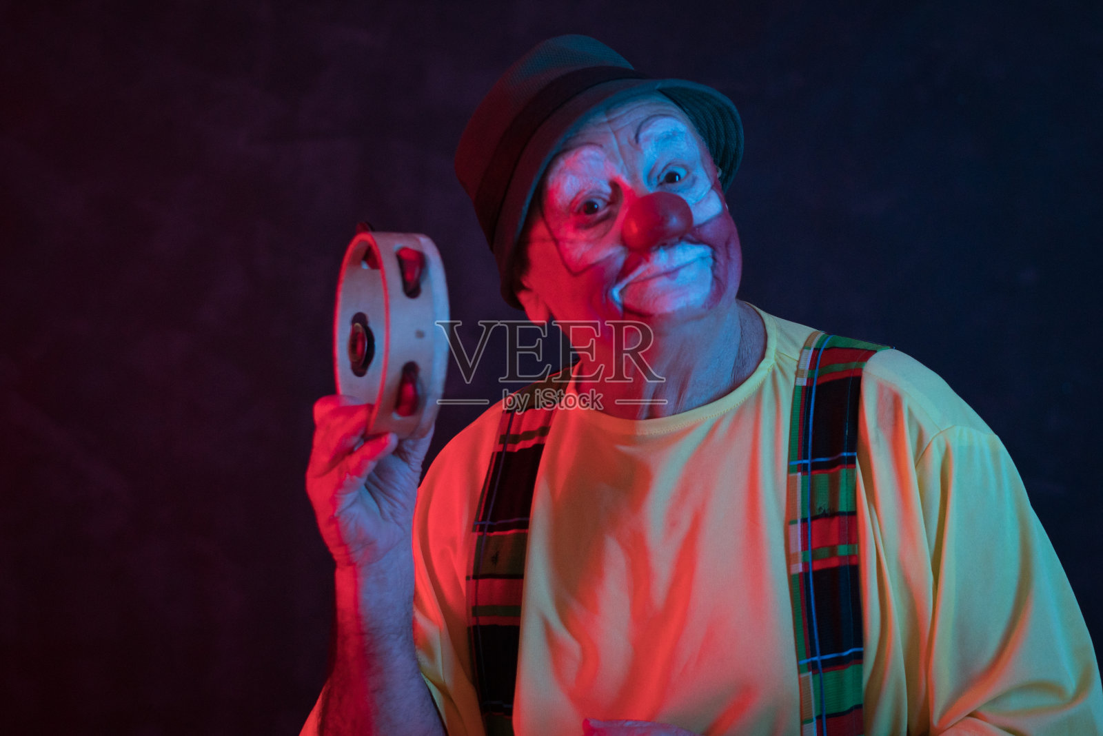 霓虹灯下的年长的滑稽演员肖像照片摄影图片
