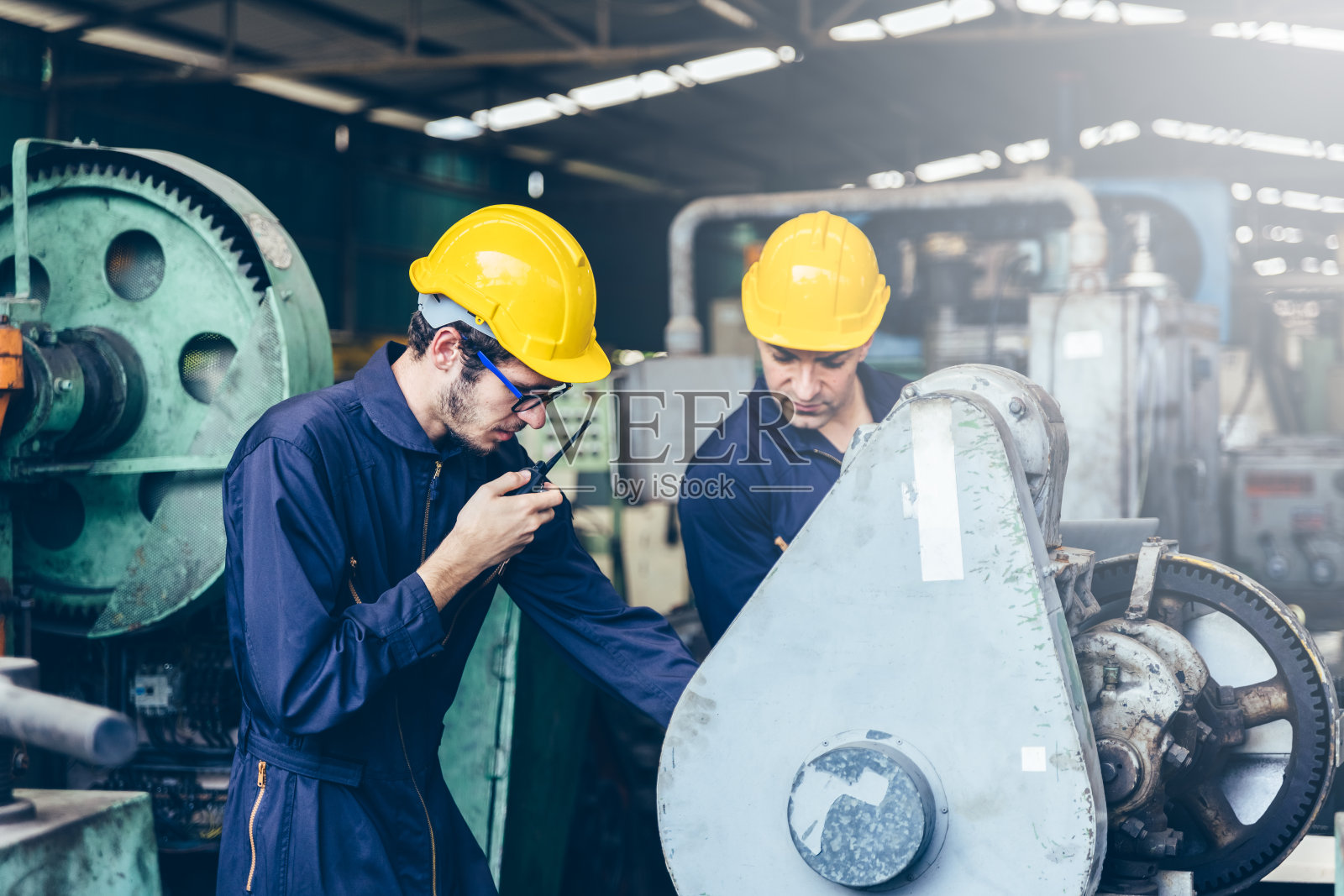 工业工厂维护工程师检查继电保护系统，使用对讲机，留有文本复制空间。工业、维护、工程和施工概念。照片摄影图片