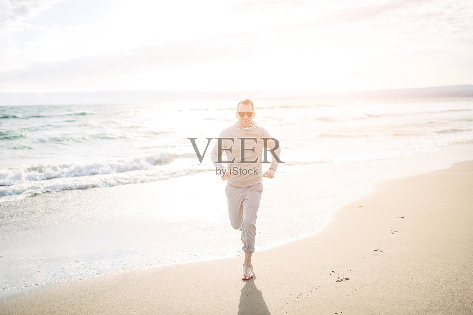 在沙滩上奔跑的快乐男人照片摄影图片