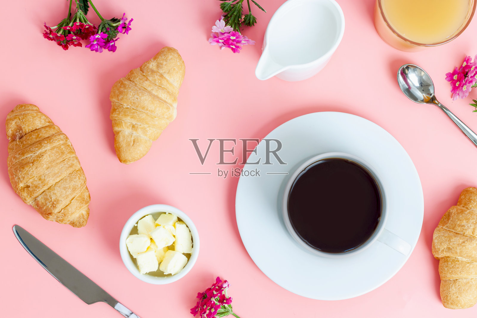 早餐咖啡、牛角面包、黄油、橙汁和白色背景上的花朵。平躺，俯视图照片摄影图片