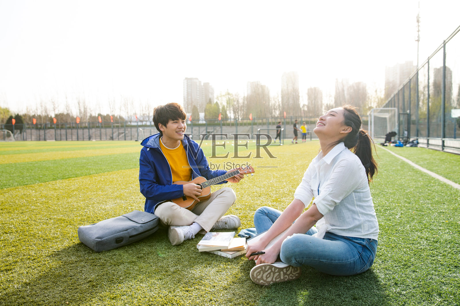 青年大学生在校园里弹奏吉他照片摄影图片