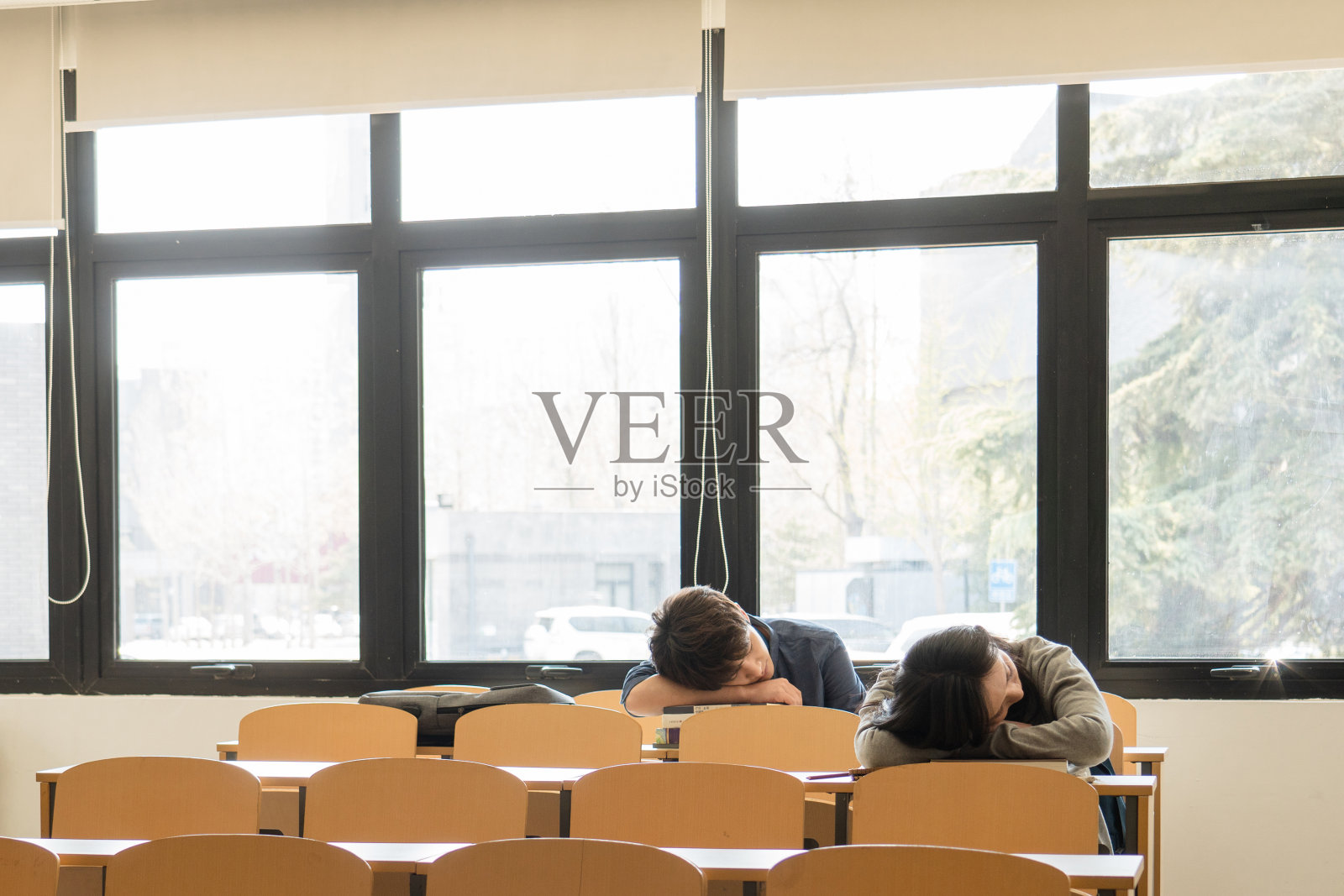 疲劳的大学生在教室里睡觉照片摄影图片