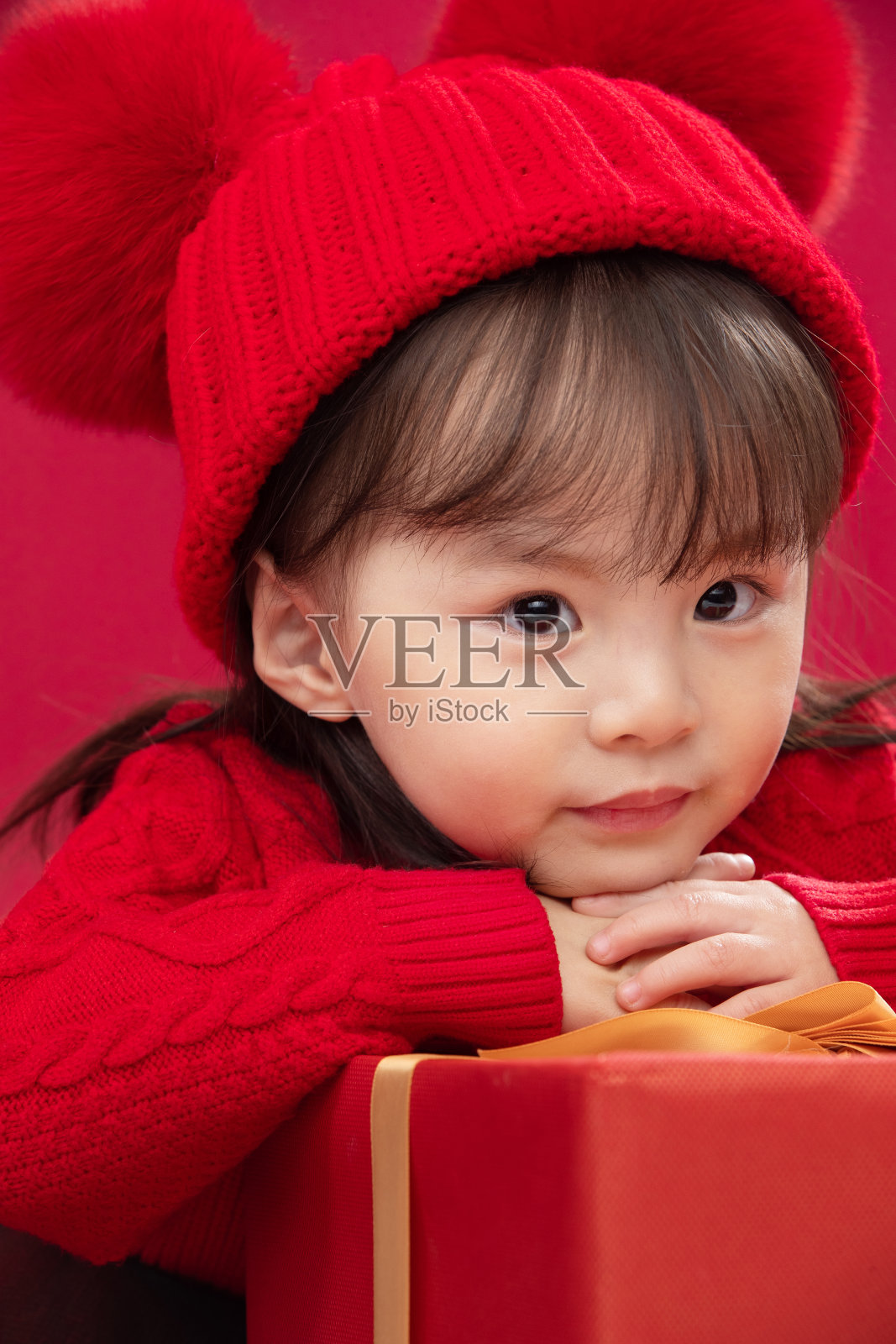 幸福的小女孩趴在礼物包装盒上照片摄影图片